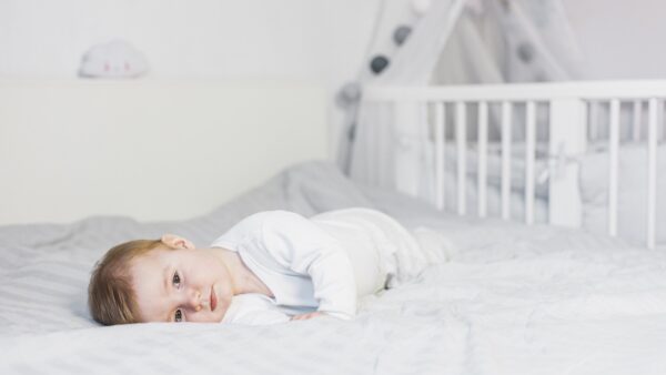 cute-blonde-baby-laying-down-white-bed (1)